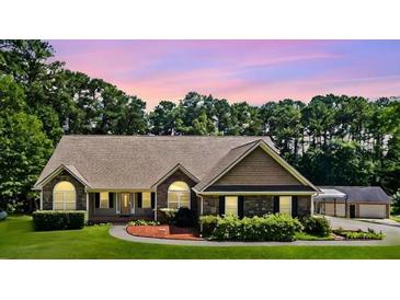 Inviting single-story home with stone accents, manicured lawn, and attached garage at 2517 N Hightower Trl, Conyers, GA 30012