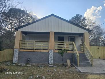 A charming home featuring gray steps, a cozy porch, and newly installed wood railings at 624 S Grand Nw Ave, Atlanta, GA 30318