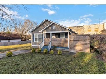 Charming one-story home with a well-manicured lawn and modern wood fence at 660 Simmons St, Atlanta, GA 30318