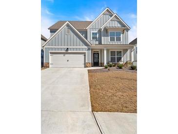 Charming two-story home with blue siding, stone accents, an attached garage, and a well-manicured lawn at 90 Citrine Way, Acworth, GA 30101