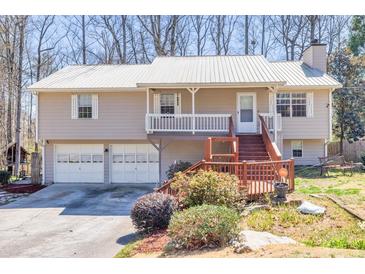Charming split-level home with metal roof, front porch, deck, and two-car garage at 3016 Ansley Manor Ct, Snellville, GA 30078
