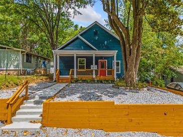 Charming blue home featuring a welcoming front porch and a beautifully landscaped front yard at 1321 Bridges Sw Ave, Atlanta, GA 30310