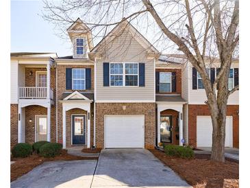Charming townhome with brick facade, blue shutters, attached garage, and inviting front entrance at 2873 Snapfinger Mnr, Decatur, GA 30035