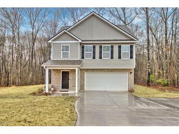 Charming two-story home featuring a brick and siding facade, front porch, and attached garage at 370 Cassidy Trl, Douglasville, GA 30134