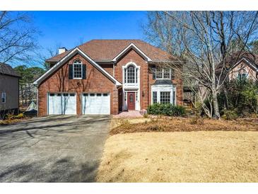 Classic brick two-story home with a two-car garage and mature trees in a well-manicured neighborhood at 724 Laurel Chase Sw, Marietta, GA 30064