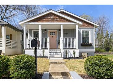 Charming home exterior with covered porch, gray siding, and a beautifully landscaped front yard at 1057 Fortress Sw Ave, Atlanta, GA 30315