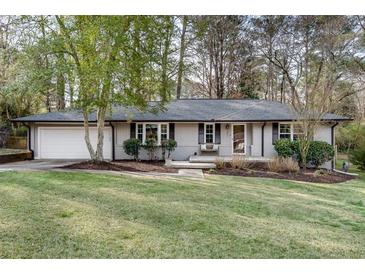 Charming single-story home with a brick facade, well-maintained lawn, and mature trees offering shade at 2031 Audubon Ne Dr, Atlanta, GA 30329