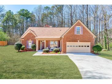 Charming single-story brick home with an attached two car garage and well manicured front lawn at 2119 Willow Chase Ct, Tucker, GA 30084