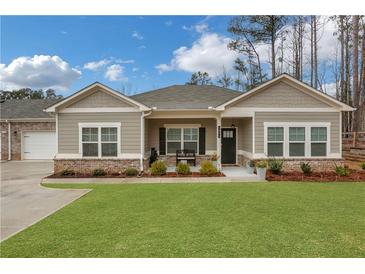 Charming single-story home featuring a lush green lawn and craftsman-style architecture on a sunny day at 3895 Shelleydale Dr, Powder Springs, GA 30127