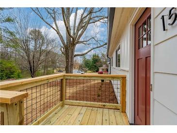 Charming home featuring a newly constructed wood porch and a classic red front door at 1506 Sycamore Nw Dr, Kennesaw, GA 30152