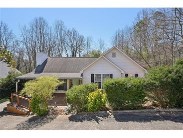 Charming one-story home featuring a gable roof, chimney, and lush landscaping at 172 Shallow Ridge Ne Ln, Kennesaw, GA 30144