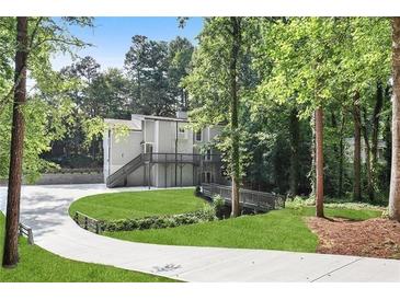 Stunning two-story home on a lush, tree-lined lot, complete with a long driveway and outdoor deck at 95 Lakeshore Ne Cir, Marietta, GA 30067