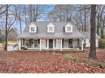 Charming home featuring a welcoming front porch with rocking chairs and swing, and a manicured front yard at 3780 Clubview Se Ct, Conyers, GA 30094