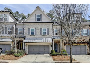 Charming townhome showcasing a brick facade, gray shutters, and a covered entryway at 112 Calder Dr, Alpharetta, GA 30009