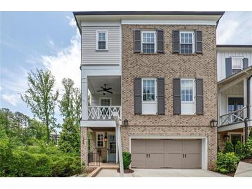 Charming two-story brick home featuring a covered porch and a two-car garage at 385 Rowes Cir, Alpharetta, GA 30009
