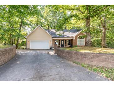 Charming single-story home featuring a brick facade, attached garage, and lush landscaping at 2208 Clarendon Ne Ct, Conyers, GA 30012