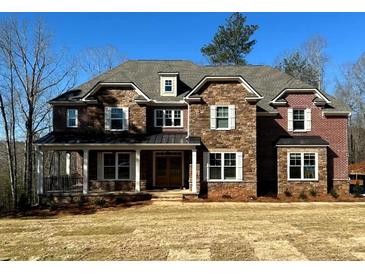 Charming two-story home with a combination of brick and stone exterior and a welcoming front porch at 7469 Waterview Cv, Douglasville, GA 30135