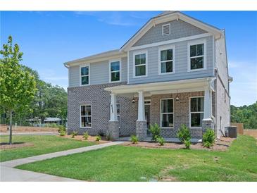 Beautiful two-story home features a brick facade, covered porch, and manicured lawn at 3387 Wild Clary Court Lot 20, Buford, GA 30519