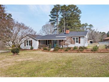 Charming single-story home with light gray siding, dark shutters, and a well-manicured front lawn at 6235 Ridge Rd, Hiram, GA 30141