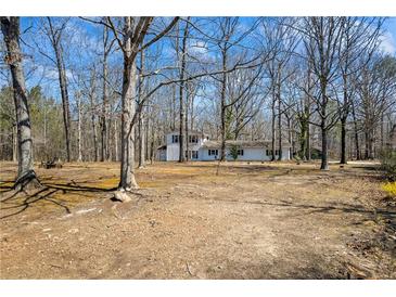 View of the home featuring a two-story design and a spacious front yard with mature trees at 94 Gilley Rd, Carrollton, GA 30116