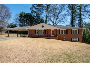Charming brick home featuring a cozy carport and a well-manicured front lawn at 1276 Kingsview Se Cir, Smyrna, GA 30080