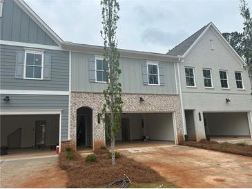 New townhomes with brick and siding exteriors, featuring open garages and landscaped front yards at 121 Priestwood Ln, Acworth, GA 30102