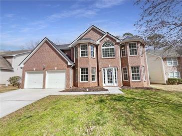 Charming brick two-story home with a two-car garage and well-maintained lawn at 624 Ironstone Dr, Fairburn, GA 30213