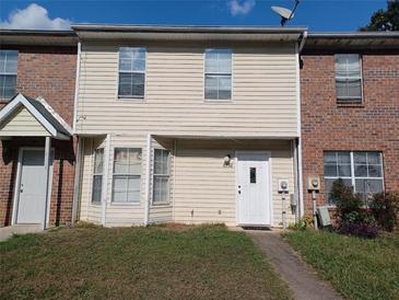 Two-story townhome with beige siding and brick accents under a blue sky at 8538 Westchester Dr, Douglasville, GA 30134