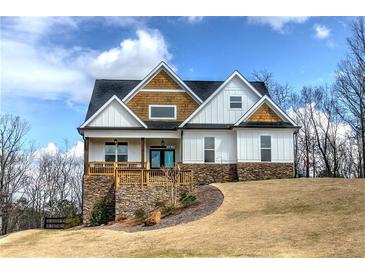 Charming two-story home with a welcoming front porch and stone accents, nestled on a lush green lawn at 64 Roberson Ne Dr, Cartersville, GA 30121