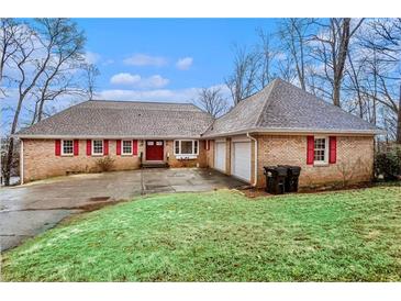 Charming brick home with a well-manicured lawn, red shutters, and a two-car garage at 448 Buckingham Dr, Marietta, GA 30066