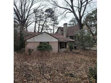 Modest single-story home with brick and siding, showcasing its potential in a mature, wooded setting at 1092 Victory Dr, Atlanta, GA 30310