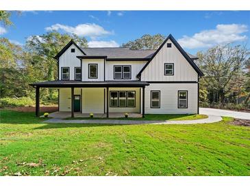 Striking two-story modern farmhouse with black-trimmed windows and a welcoming covered front porch at 2788 Browns Mill Se Rd, Atlanta, GA 30354