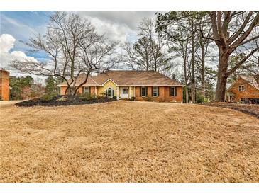 Charming single-story home with a brick facade, yellow trim, and well-manicured lawn at 573 Ripplewater Sw Dr, Marietta, GA 30064