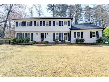 Charming two-story home boasts a classic white exterior and a well-manicured front yard at 1643 North Springs Dr, Dunwoody, GA 30338