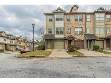 View of townhome exterior featuring attached garages, street view, and manicured front lawns at 2819 Hillside Way, Decatur, GA 30034