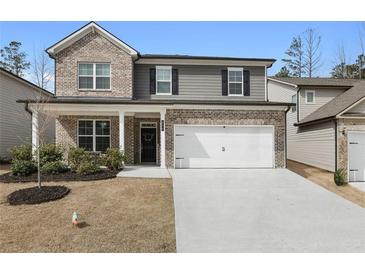 Charming two-story home with a brick and siding facade, attached garage, and well-manicured front lawn at 514 Cunninghame Ct, Peachtree City, GA 30269
