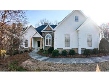 Beautiful home with stone accents, a curved walkway, and manicured landscaping at 3619 Elinburg Ne Ct, Buford, GA 30519