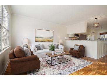 Cozy living room with bright natural light, hardwood floors, and view into the kitchen at 2232 Dunseath Nw Ave # 303, Atlanta, GA 30318