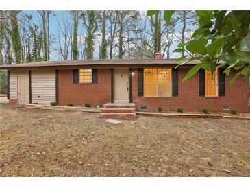 Charming red brick single-story home with a cozy front yard and freshly painted trim at 6852 Old Beulah Rd, Lithia Springs, GA 30122