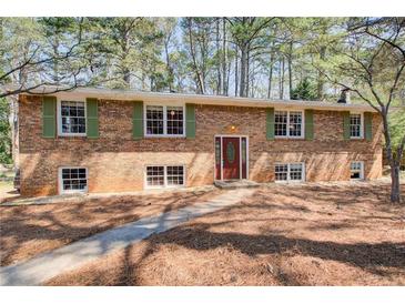 Charming two-story brick home with green shutters and a well-manicured front yard at 410 Killian Hill Sw Rd, Lilburn, GA 30047
