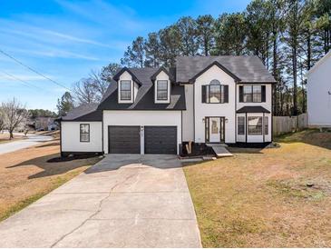 Charming two-story home with a two-car garage, landscaped front yard, and a welcoming entrance at 6107 Waterton Dr, Lithonia, GA 30058