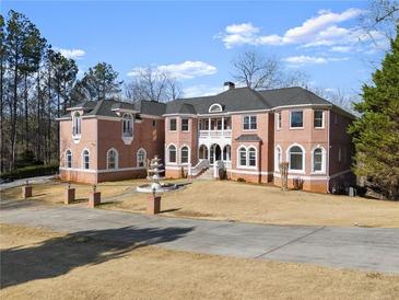 Stunning brick mansion featuring a fountain, manicured lawn and a circular driveway at 10 Club Ct, Alpharetta, GA 30005