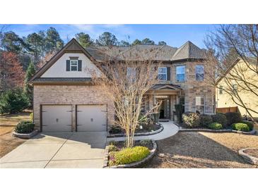 Charming two-story brick home featuring a well-manicured front yard, a two-car garage, and professional landscaping at 2040 Bloomfield Ct, Cumming, GA 30041