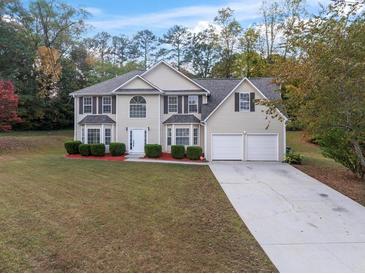 Charming two-story home with a manicured lawn and a two-car garage at 3529 Riverview Approach, Ellenwood, GA 30294