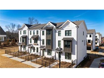 Stunning three-story townhome featuring brick facade, sleek black windows, and professional landscaping at 504 Healy Dr # 75, Cumming, GA 30040