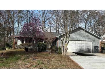 Charming one-story home featuring an attached garage and a well-maintained front yard with flowering trees at 1302 Buttercup Ct, Lawrenceville, GA 30044