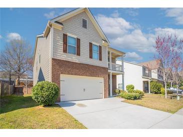 Charming two-story home featuring a brick and shingle exterior with a front-facing two car garage and a second story balcony at 7416 Toccoa Cir, Union City, GA 30291