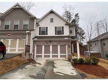 Charming two-story townhome with brick accents and a two-car garage in a well-kept community at 338 Cherryhill Ln, Woodstock, GA 30188