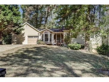 Charming single-Gathering home featuring a front lawn, attached garage, and covered front porch at 4304 Ruth Ln, Powder Springs, GA 30127