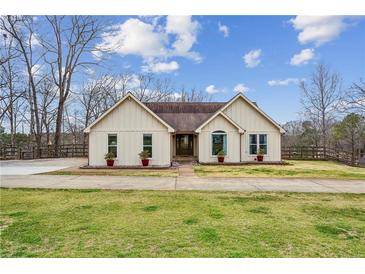 Charming single-story home with a well-manicured lawn, light siding, and lovely landscaping at 8 Colonial Club Se Dr, Acworth, GA 30102